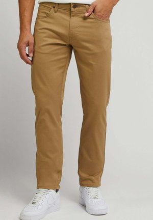 Chinos marroni chiari con vestibilità dritta, dotati di tasche frontali e chiusura con bottone, abbinati a sneakers bianche. Tessuto liscio e resistente.