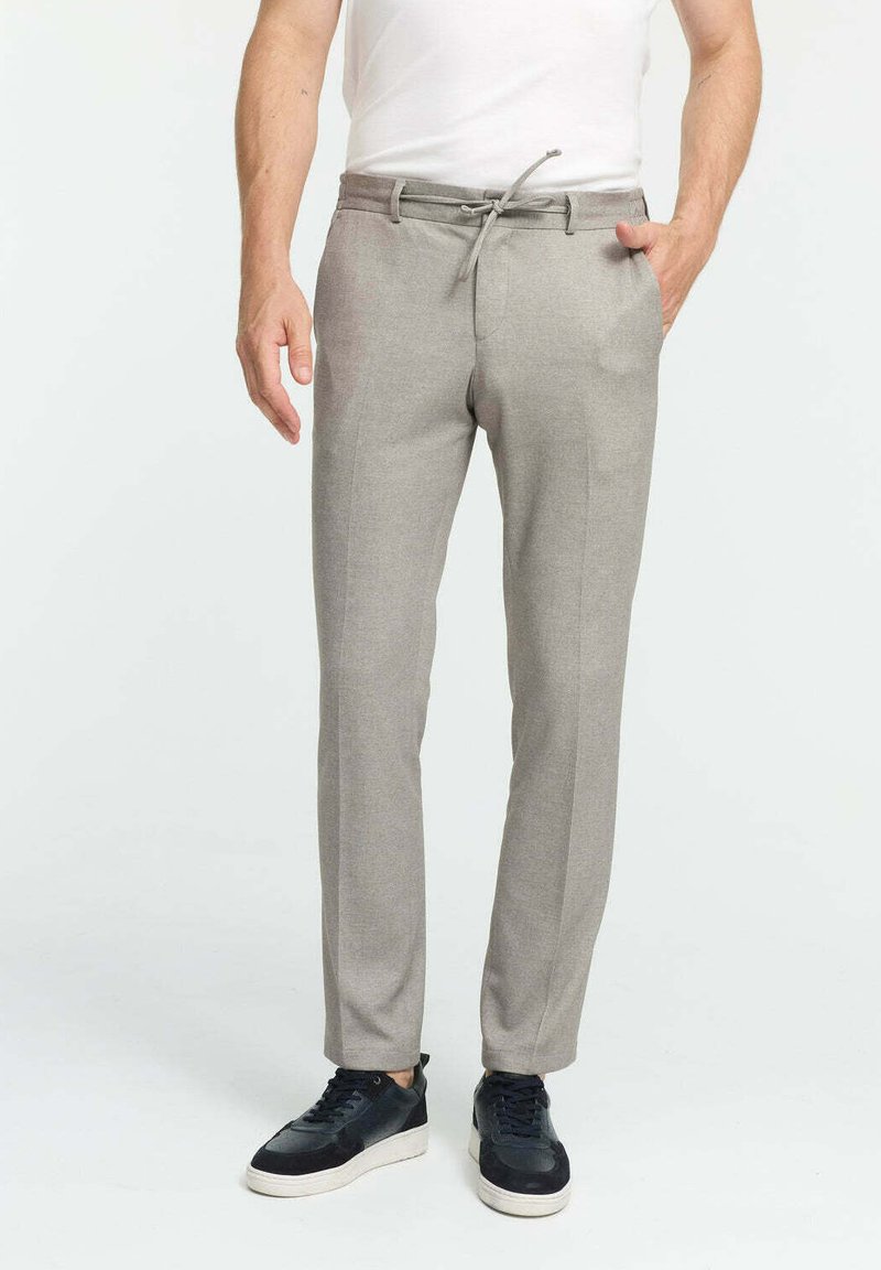 Light gray tailored pants with a drawstring waist, smooth texture, and front crease details. Paired with black sneakers.