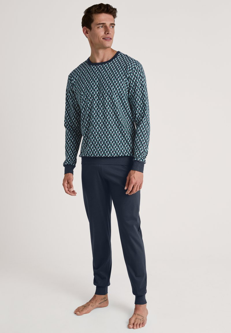 Marineblauwe pyjama set met een langetermijn top met een geometrisch patroon en bijpassende broek met omslag, gemaakt van zacht materiaal.
