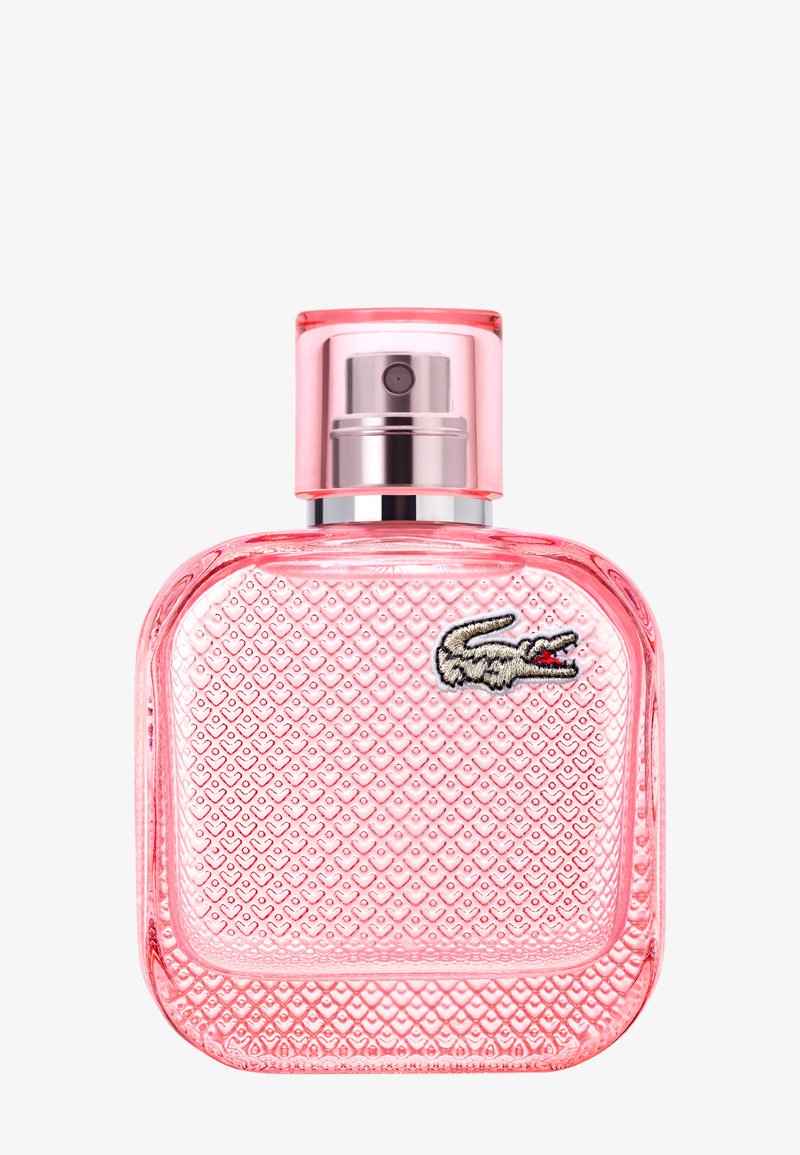 Flacon de parfum en verre texturé rose avec pulvérisateur argenté et petit logo crocodile brodé sur le devant.