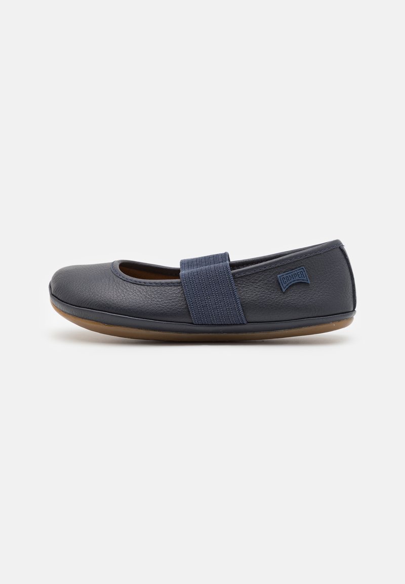 Navy leather ballet flats with an elastic strap, a round toe, and a rubber sole. Textured upper and subtle branding on the heel.