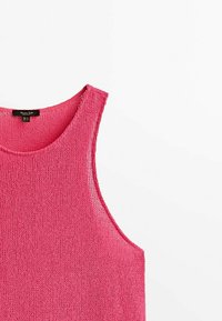 Débardeur en tricot rose avec un col rond et des emmanchures larges. La texture est légère et en maille ouverte, adaptée aux temps chauds.