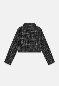Krótkie czarno-białe tweedowe żakiety z długimi rękawami, spiczastym kołnierzem i fakturowanym wzorem. Zawiera kontrastujące czarne wykończenie.