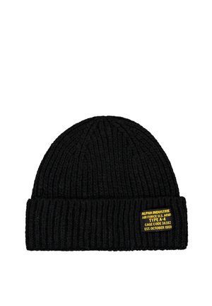 Schwarze gerippte Strickmütze mit umgeschlagenem Bündchen und kleinem gelbem Etikett mit militärischem Text.