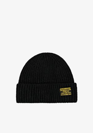 Black ribbed knit beanie hat with a folded cuff and a small yellow label showing military-style text.