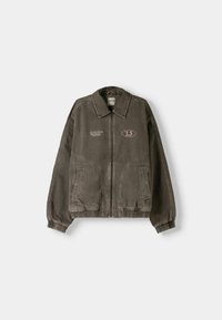 Khaki zipová bunda z těžké bavlny s límcem, elastickými manžetami, bočními kapsami a výšivkami na hrudi a v levém horním rohu.