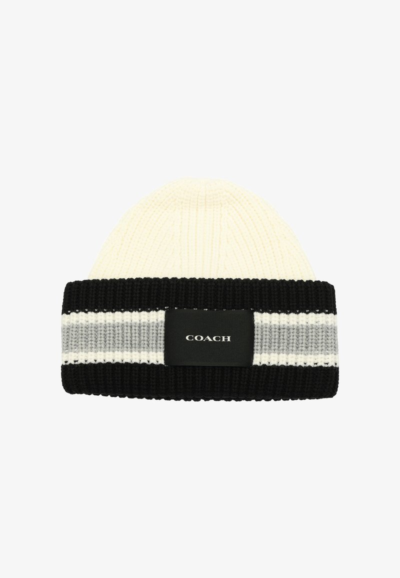Knit beanie in cream with a black ribbed cuff. Features gray and white stripes and a black label with "COACH" logo. Soft texture.