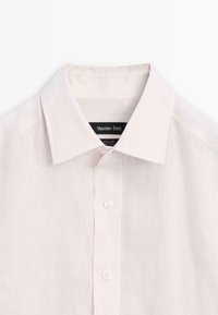 Lichtroze linnen overhemd met een puntkraag, voorzien van een knoopsluiting aan de voorkant en een subtiele textuur. Merkenlabel "Massimo Dutti" is zichtbaar.