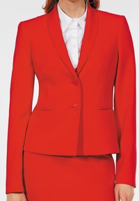 Blazer rouge sur mesure avec un revers cranté, fermeture à un bouton et deux poches frontales. Fabriqué en tissu lisse avec des détails de couture minimaux.
