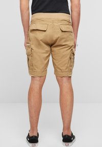 Khakifargede cargoshorts med avslappet passform, med flere sidelommer, oppbrettet kant og et teksturert bomullsstoff.
