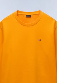 Felpa arancione in misto cotone, con colletto a girocollo ribbed e piccolo emblema della bandiera norvegese sul petto per un tocco di dettaglio.