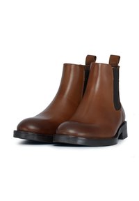 Stivali Chelsea in pelle marrone con pannelli laterali elastici, punte arrotondate e tacco basso nero, caratterizzati da una superficie liscia e lucida.