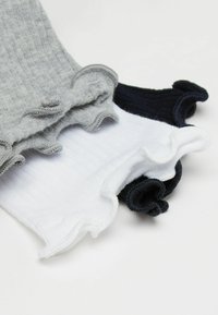 Trzy pary skarpetek typu ankle: jasnoszare, białe i ciemnogranatowe. Każda z nich ma falbaniasty mankiet i delikatną żebrowaną strukturę.