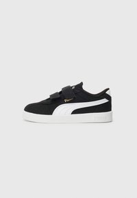 Chaussures en suede noir avec logo blanc, dotées d'un col rembourré, de deux bandes Velcro et d'une semelle en caoutchouc blanc pour une meilleure adhérence.