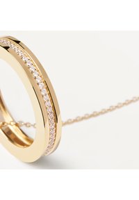 Anello d'oro con una superficie liscia, caratterizzato da una fila di piccole pietre trasparenti lungo la fascia. Catena delicata attaccata, che esalta il design.