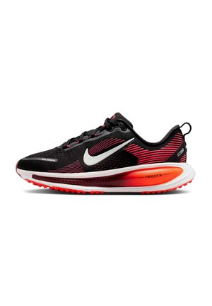 Chaussures de course Nike, noires avec des accents rouges, tige en mesh, semelle intermédiaire avec amorti React, semelle extérieure texturée et détail du logo réfléchissant.