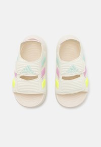 Adidas sandaler i hvit med to justerbare stropper. Har pastellfarger i rosa, blå og gul. Teksturert såle for bedre grep.