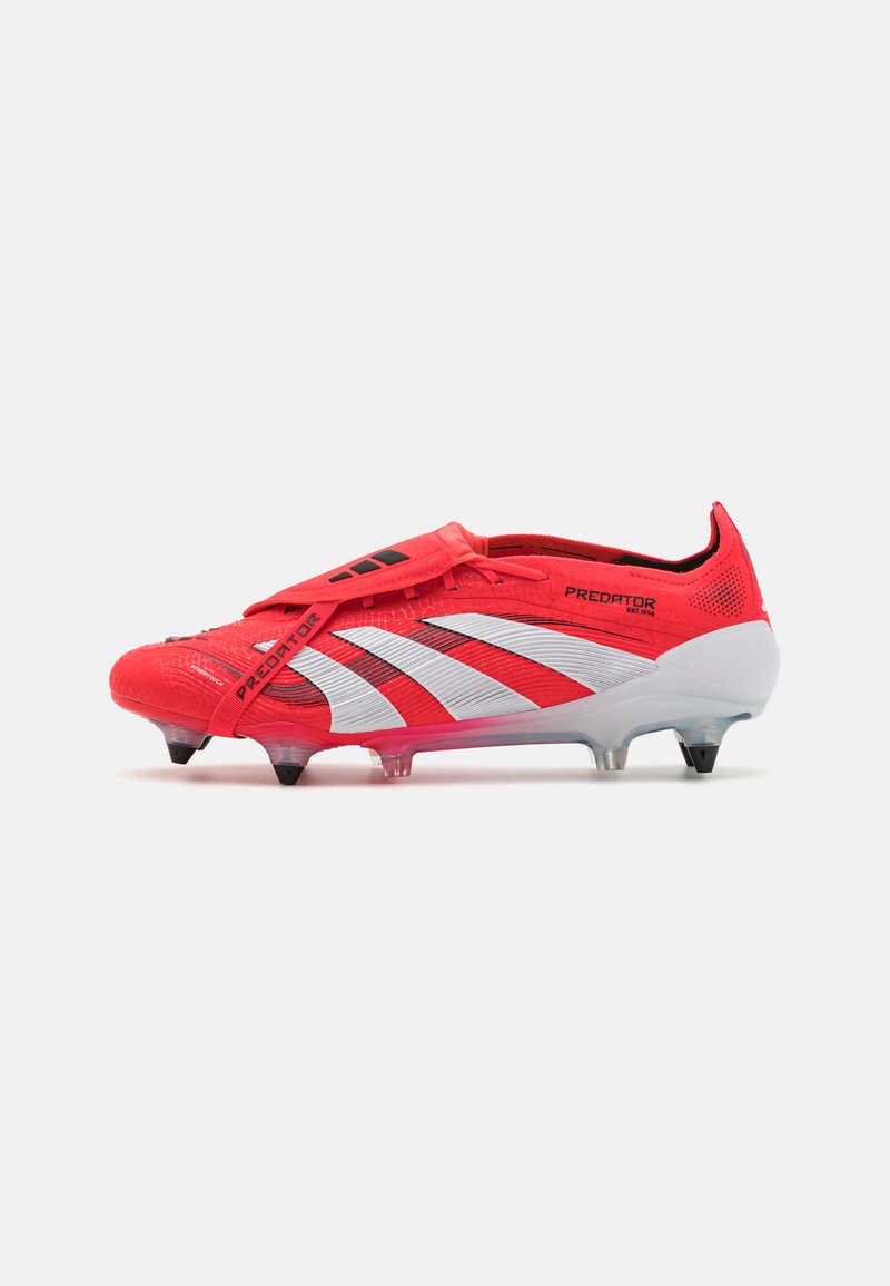 Crampons de football rouges avec un dessus synthétique texturé, des rayures blanches et une sangle noire. Présente des crampons transparents sur la semelle pour une meilleure traction.