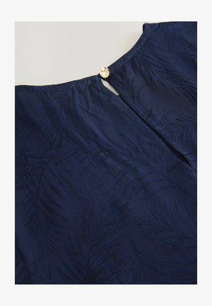 Marineblaue Bluse mit strukturiertem Blattmuster, Rundhalsausschnitt und dekorativem goldenen Knopfverschluss auf der Rückseite.