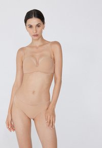Nagi zestaw bielizny składający się z biustonosza z poduszkami i regulowanymi ramiączkami oraz gładkich majtek typu bikini, o gładkiej fakturze i minimalistycznym wzornictwie.