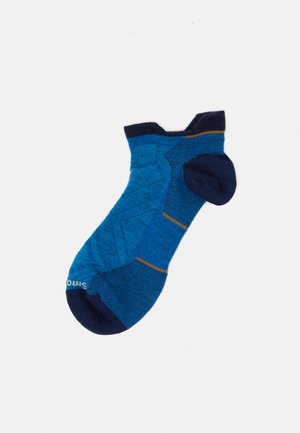 Meia azul e azul-marinho com padrão, apresentando um design texturizado e uma faixa de destaque laranja. Confeccionada a partir de uma mistura de materiais macios.
