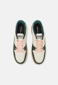 Lacoste sneakers in white leather with green and pink accents. Features rounded toe, perforated upper, and rubber sole with a textured finish.