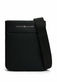 Borsa a tracolla nera realizzata in nylon testurizzato, con tasca frontale, cinturino regolabile e logo "TOMMY HILFIGER" in argento sulla parte anteriore.