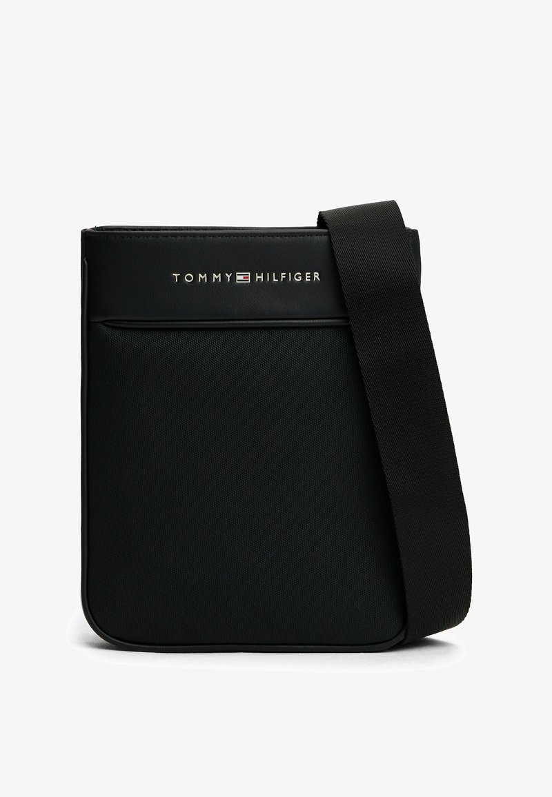 Borsa a tracolla nera realizzata in nylon testurizzato, con tasca frontale, cinturino regolabile e logo "TOMMY HILFIGER" in argento sulla parte anteriore.