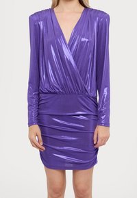 Fialové dlouhé šaty s dlouhým rukávem vyrobené z lesklé a elastické tkaniny, s hlubokým výstřihem do V, plisovanými rameny a nařaseným pasem s volánkovou texturou.