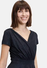 Robe portefeuille en tissu bleu marine foncé avec un léger éclat, featuring des manches courtes et un décolleté en V profond, taille froncée et boutons décoratifs.