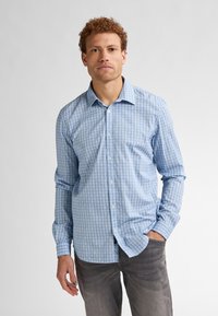 Camicia azzurra a maniche lunghe con un design a motivo. Presenta un colletto classico e bottoni sul davanti, realizzata in un tessuto liscio.