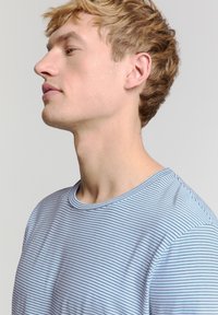 Blauwe en witte gestreepte T-shirt met een ronde hals, gemaakt van zachte stof. Zichtbare naden en een gladde textuur. Getailleerde stijl.