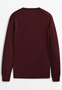 Bordeaux trui met lange mouwen, ronde hals en geribbelde manchetten. Gladde textuur en eenvoudig ontwerp, met een effen kleur zonder patronen.