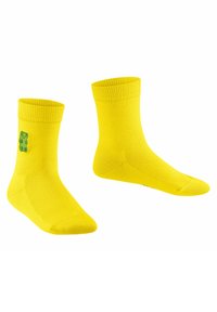 Gelbe Baumwollsocken mit einem gerippten Bund und einem grünen Gummibärchen-Motiv an der Seite. Sie haben eine Standardhöhe für Crew-Socken und eine glatte Textur.