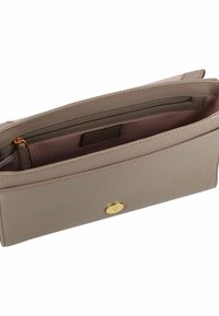 Beige Brieftasche aus strukturiertem Material mit einem goldenen Druckknopfverschluss, ausgestattet mit einem Reißverschlussfach und einem pinken Innenfutter.