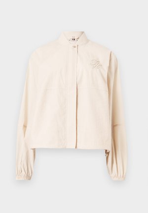 Hellbeige kurz geschnittene Jacke mit hohem Kragen, vorderer Druckknopfverschluss, elastischen Bündchen und gesticktem Logo auf der Brust.