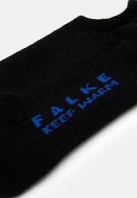 Sort sok lavet af glat materiale med blå tekst, der står "FALKE KEEP WARM." Designet inkluderer en standard ankelhøjde.