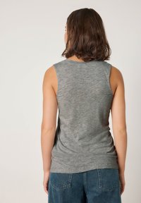 Siv brezrokavnik iz lahkega blaga, z zaobljenim izrezom in sproščenim krojem. Pogled od zadaj prikazuje gladko teksturo in minimalne detajle.