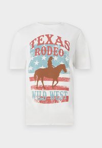Hvit bomulls T-skjorte med en cowboy på hest, med en rød og blå "Texas Rodeo Wild West"-grafikk, med slitt tekstur og stjernebakgrunn.