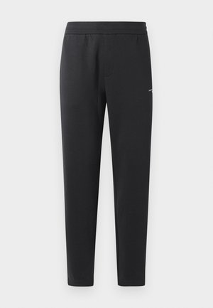 Sorte joggebukser laget av myk stoff, med elastisk midjebånd, rette ben og en liten logo detalj på siden.