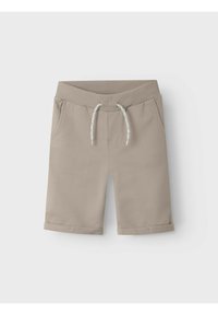 Pantalones cortos de algodón beige con una cinturilla elástica, cordón decorativo, dos bolsillos laterales y dobladillos enrollados. Textura suave, diseño casual.