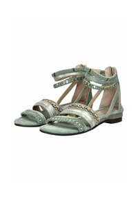 Grüne Sandalen mit mehreren Riemen, dekorativen Verzierungen inklusive Perlen und metallischen Akzenten, flacher Sohle und offener Zehenpartie.
