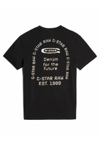 T-shirt noir en coton avec un texte blanc et crème au dos, incluant "G-Star Raw" et "Denim pour l'avenir" dans un design circulaire.