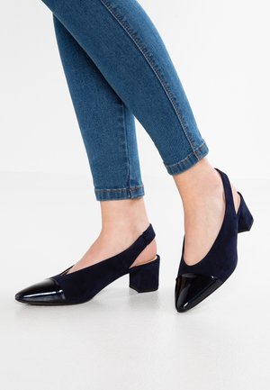 Granatowe buty na obcasie typu slingback z noskiem w szpic, z błyszczącą skórzaną czapką i fakturowanym zamszowym korpusem, na umiarkowanie szerokim obcasie.