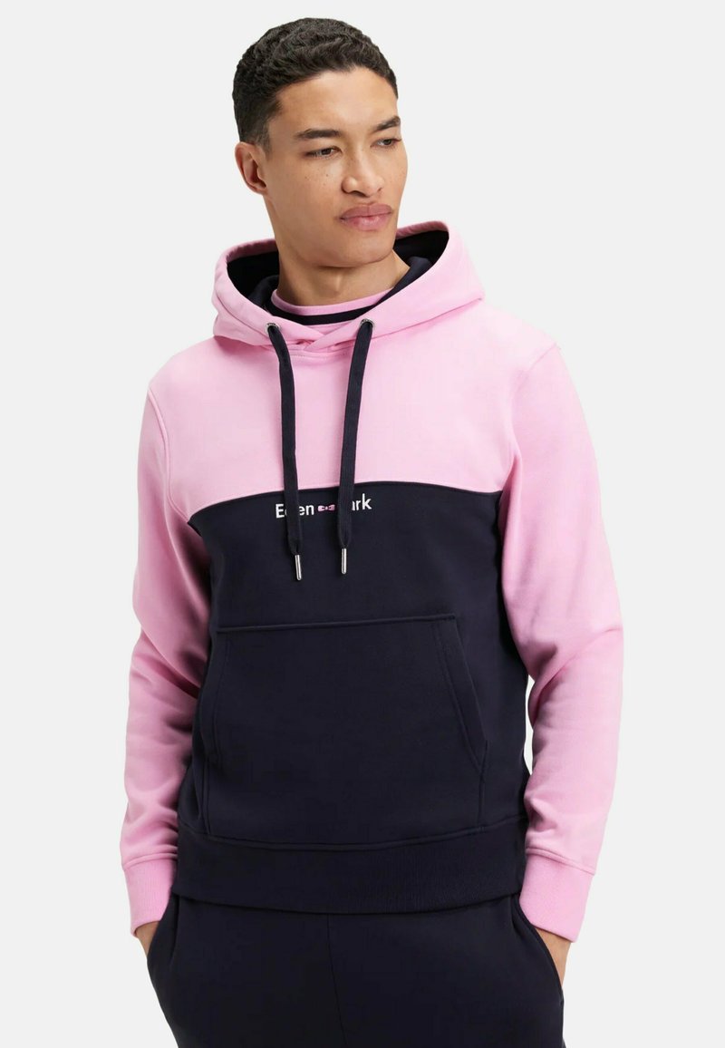 Sweat-shirt à capuche avec un haut rose et un bas bleu marine, fabriqué en tissu doux, doté d'une poche frontale et de cordons de serrage. Logo "Even&mark" affiché.