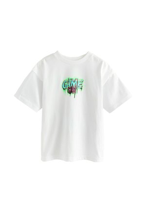 Camiseta blanca de algodón con mangas cortas que presenta un gráfico colorido de "¡JUEGO ACTIVADO!" en un diseño goteante en verde y negro en la parte frontal.