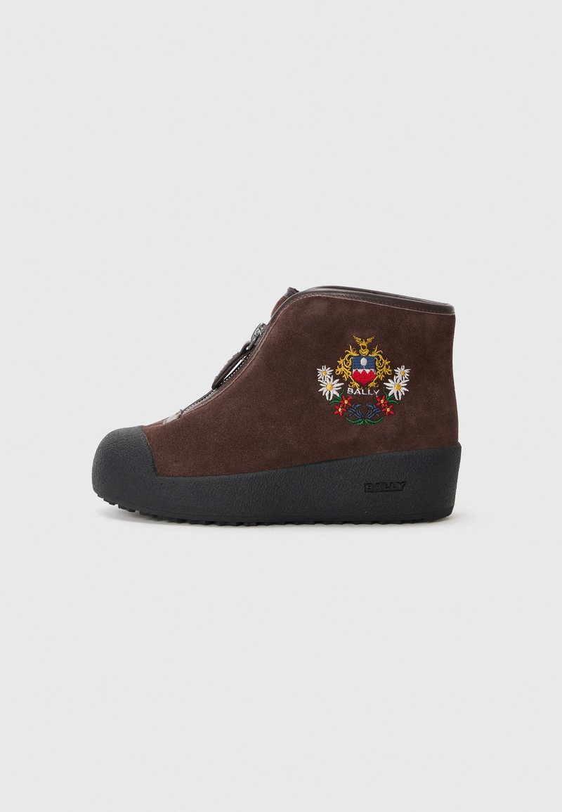 Stivale alla caviglia in suede marrone con cerniera laterale, suola nera gommata e design ricamato con un emblema che presenta fiori e la parola "BALLY."