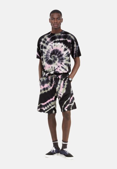 Sæt bestående af en sort tie-dye bomulds t-shirt og shorts med spiralmønstre i lilla og pink. T-shirten har et logo; shortsene har lommer og snøre.