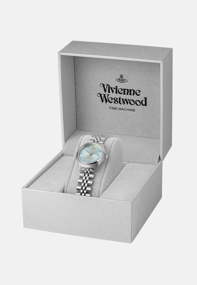 Montre Vivienne Westwood dans une boîte grise. Elle possède un bracelet argenté, un cadran rond bleu clair, des aiguilles argentées et le logo de la marque sur le boîtier.