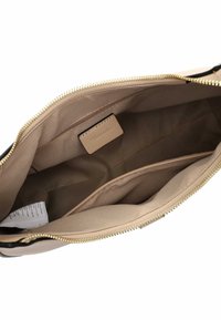 Interior de bolso beige con forro crema, cremallera dorada y un pequeño bolsillo. Compartimentos adicionales para organización y etiqueta presente.